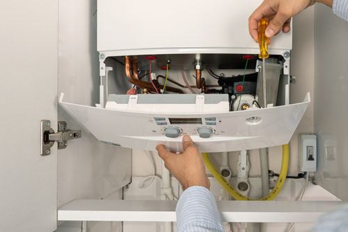 Heating technician repairing a residential boiler in Hacienda Heights