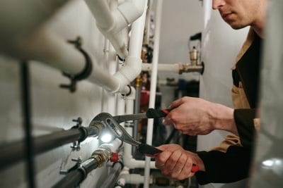 Technician inspecting commercial plumbing pipes in Hacienda Heights
