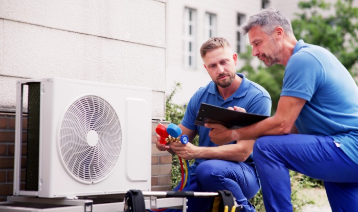 HVAC technicians installing an outdoor air conditioning unit in Hacienda Heights