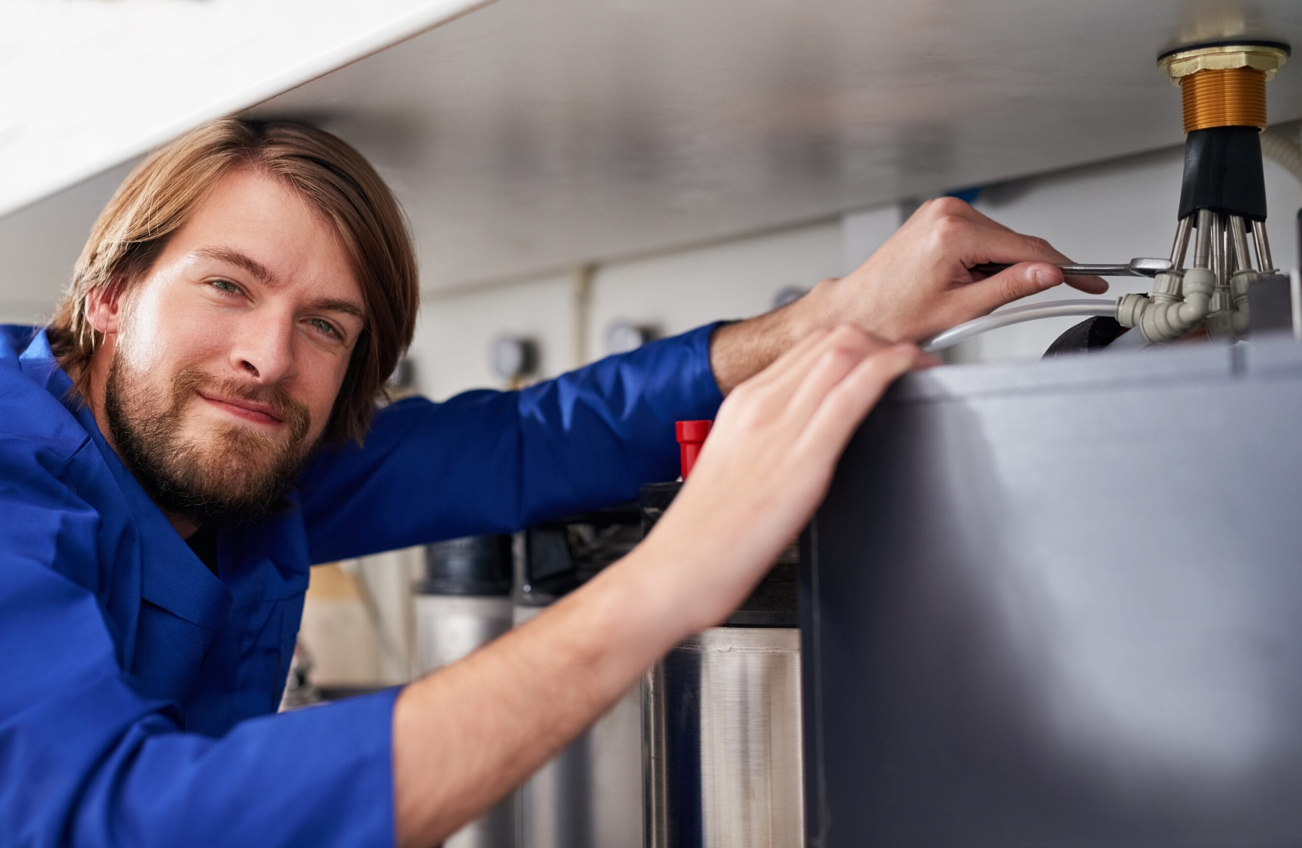 Technician servicing a residential water heater tank in Hacienda Heights